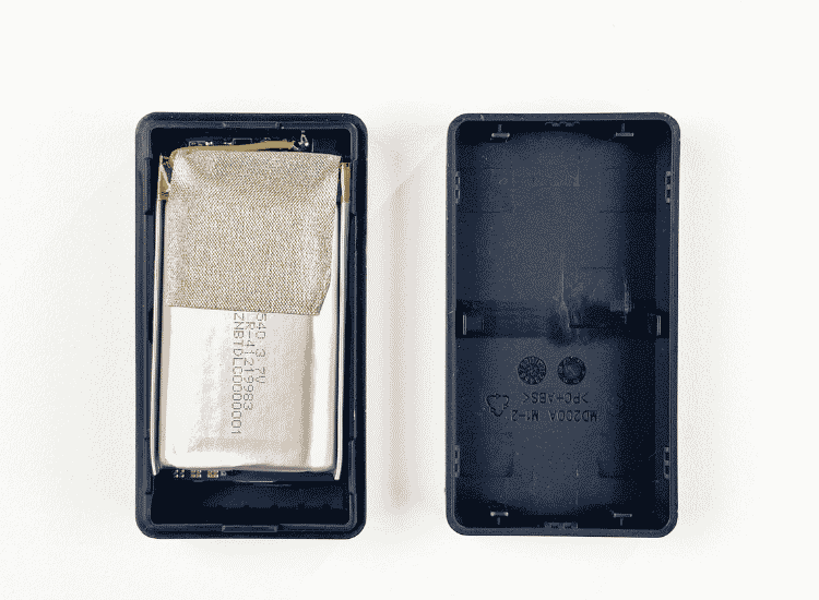 JioFind 4G opened with a pry tool during GPS tracker teardown, revealing the battery